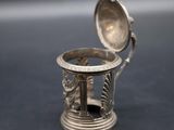a silver ring with a spoon in it sitting on a table