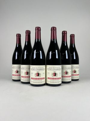 six bouteilles de vin sont alignées sur une table