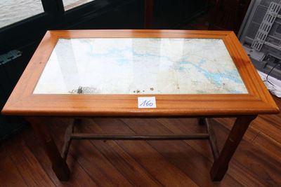 une table en verre sur laquelle est posée une carte, posée sur un parquet