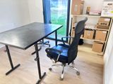 un bureau avec une chaise noire et un plateau noir