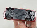 a person holding a red toy truck in their hand