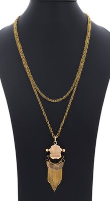 un mannequin portant une chaîne en or et un pendentif orné d'une pierre rose