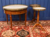 two tables with marble tops sit on a rug in front of a blue wall