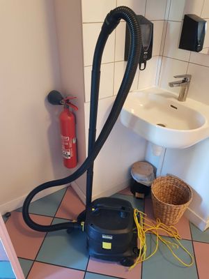 un aspirateur posé par terre à côté d'un évier