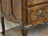 a wooden chest of drawers with a marble top