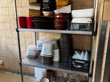 a metal shelf with dishes on it in a kitchen