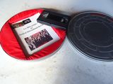 une assiette rouge sur laquelle sont posés un livre et un appareil photo