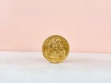 a gold coin sitting on top of a white surface