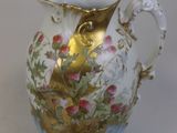 un vase blanc et doré orné de fleurs