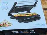 une boîte contenant un appareil à sandwich, posée sur une table en bois