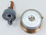 a barometer and a clock sitting on a table