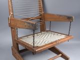 an old wooden chair with a roped seat on a gray background