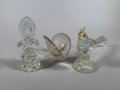 three glass figurines sitting on a white surface