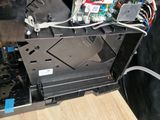 a black dog that is standing next to a dishwasher