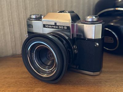 un appareil photo posé sur une table à côté d'un appareil photo noir