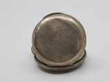 a close up of a silver pocket watch on a white surface