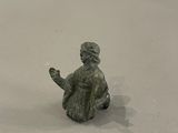 une petite figurine représentant un homme assis sur un skateboard