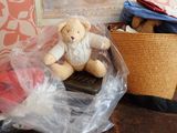 un ours en peluche posé dans un sac en plastique à côté d'un panier posé sur une table