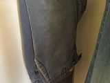 a pair of jeans hanging on a hanger next to a pair of jeans