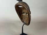 wooden sculpture of a bird perched on a shell on a black stand