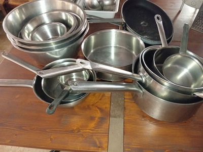many pots and pans sitting on a wooden table