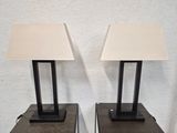 une paire de lampes de table en métal noir avec des abat-jours blancs