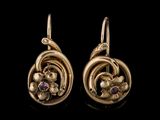 une photo d'une paire de boucles d'oreilles en or ornées de pierres violettes
