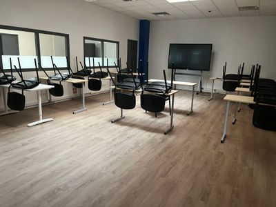 tables and chairs in a room with a flat screen tv