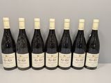 six bouteilles de vin sont alignées sur une table