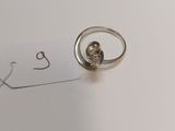 a silver ring with a diamond on it sitting on top of a piece of paper