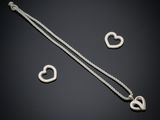 a silver necklace with two heart charms on a black background