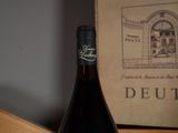 a bottle of wine sitting on a table next to a box of wine