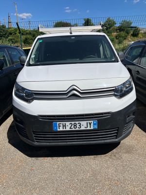 une camionnette blanche garée dans un parking à côté d'autres voitures