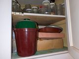 de nombreuses casseroles et poêles sur les étagères de la cuisine