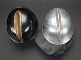pair of silver and gold helmets on a black surface