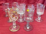 a lot of wine glasses sitting on a red cloth