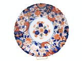 a plate with a floral design on it on a stand