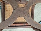 a close up of a wooden chair with a wicker seat