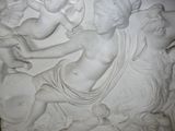 a large white relief of a woman and two cherenshes