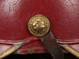an old red helmet with a gold lion emblem on it