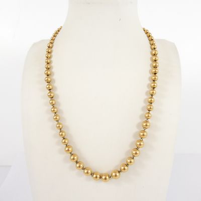 a gold beaded necklace on a mannequin mannequin mannequin mannequin mannequin mannequin mannequin mannequin mann