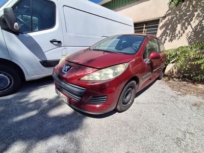 une petite voiture rouge garée devant une camionnette blanche