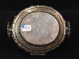 a silver plate with a picture on it on a black surface