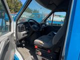 a blue truck with the door open and the driver ' s seat in the back