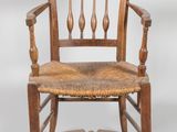 an old wooden chair with a woven seat and arm rest