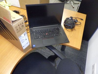 un ordinateur portable posé sur un bureau, à côté d'une chaise
