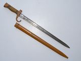 an old sword with a wooden handle sitting on top of a table