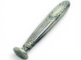 une cuillère en argent avec un manche sur une surface blanche