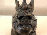 bronze statue of a gargoy on a black base with a white background