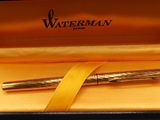 an image of a pen in a box with a yellow ribbon around it